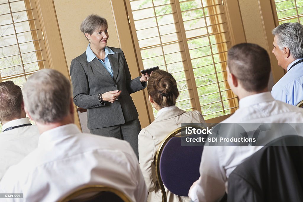 Mature Femme d'affaires de parler à un groupe de professionnels - Photo de Femmes d'âge mûr libre de droits