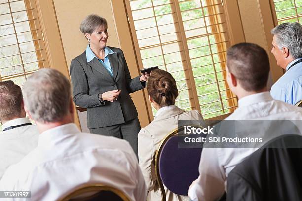 Photo libre de droit de Mature Femme Daffaires De Parler À Un Groupe De Professionnels banque d'images et plus d'images libres de droit de Femmes d'âge mûr