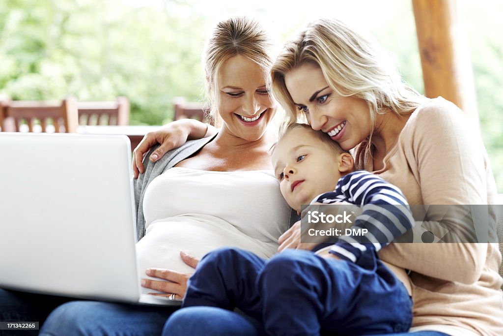 Linda família olhando para o laptop pouco - Foto de stock de Lésbica royalty-free