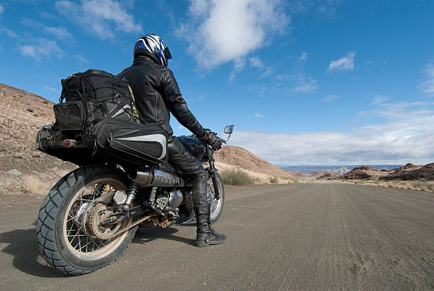 motorcyclist stops to appreciate view motorcyclist in leathers stops on a dirt road to appreciate the view of the fish river canyon in Namibia. self portrait. motorcycle racing stock pictures, royalty-free photos & images