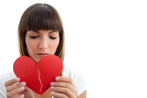 Pensive Girl breaking a paper heart.See similars: