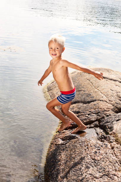 istock Small blond boy ready to jump into the sea. 171342725