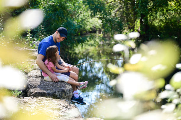 istock affectionate father playing with his daughter near a riverbank. 1713428833