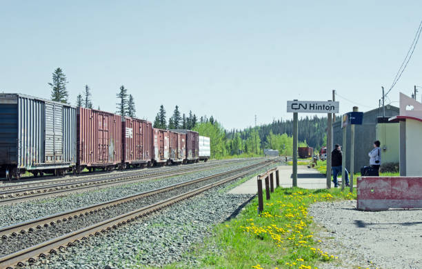 Hinton Railroad Stop "Edson, Canada - May 27, 2012: In the town of Hinton two people are waiting for a Via passenger train that goes between Edmonton and Jasper, Alberta. Hinton is on the Yellowhead Highway between Jasper and Edmonton." hinton alberta stock pictures, royalty-free photos & images