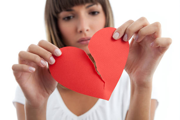 Broken Heart Girl Pensive Girl breaking a paper heart.See similars: infidelity photos stock pictures, royalty-free photos & images