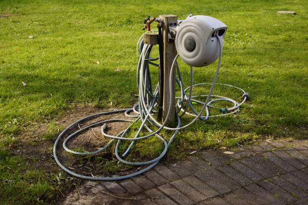istock Garden hose reel on green lawn in backyard 1713446655