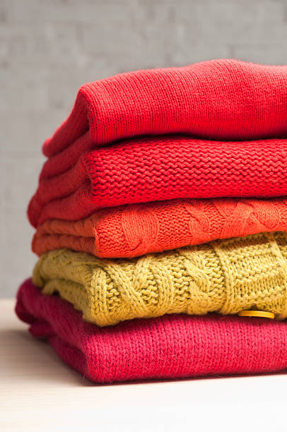 pile of colorful sweaters stock photo