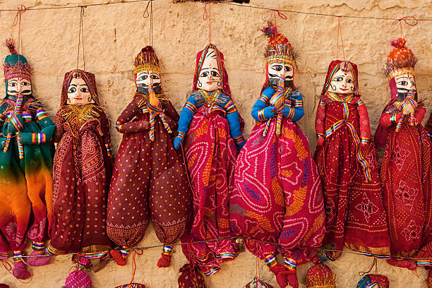 Colorful Indian puppets for sale The puppets in Rajasthan are one of the most popular sources of entertainment in the state. The art of puppetry is practiced by a community of agricultural laborers of Rajasthan. The puppets are generally two feet in height having a wooden head with an enormous nose and large eyes. The rest of the body is made of colourful and bright pieces of cloth and stuffed rags which also allow for free movement. tribal art photos stock pictures, royalty-free photos & images