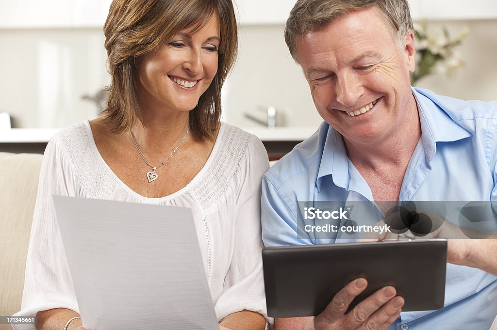 Casal pagar a conta on-line, usando um tablet digital - Foto de stock de Casal de Meia Idade royalty-free