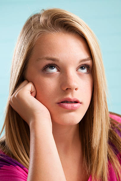 Lovely blonde teenage girl rolling her eyes upward. Lovely blonde teenage girl rolling her eyes upward. rolling eyes stock pictures, royalty-free photos & images