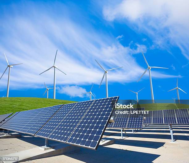 Solar Panels And Wind Turbines In A Green Field Stock Photo - Download Image Now - Solar Panel, Wind Turbine, Solar Energy