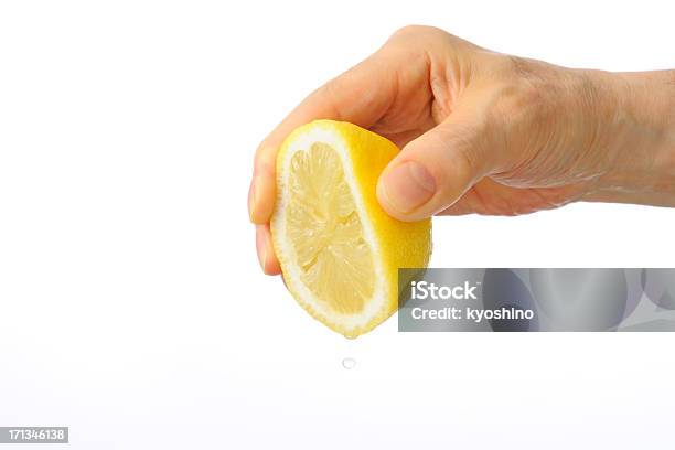 Isolated Shot Of Hand Squeezing A Lemon Against White Background Stock Photo - Download Image Now