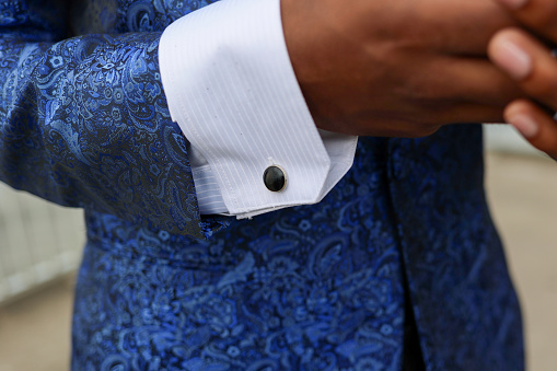 A close up of a Black man in a blue tuxedo