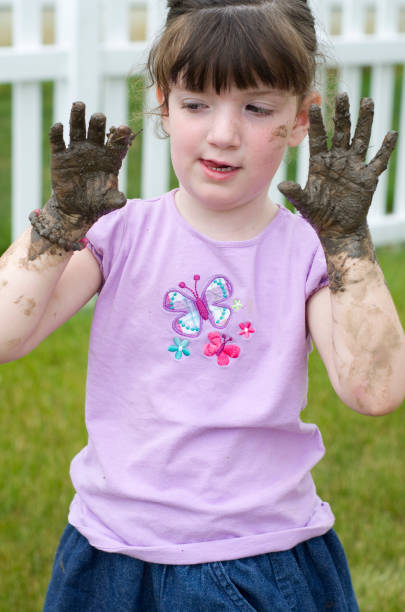istock little girl holds up her muddy hands 171347163
