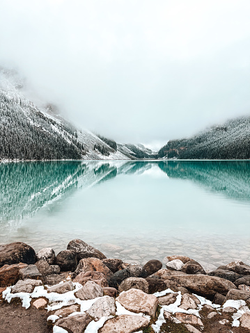 Unique moment at Lake Louise at the end of September with snow on the trees but the water is still unfrozen.