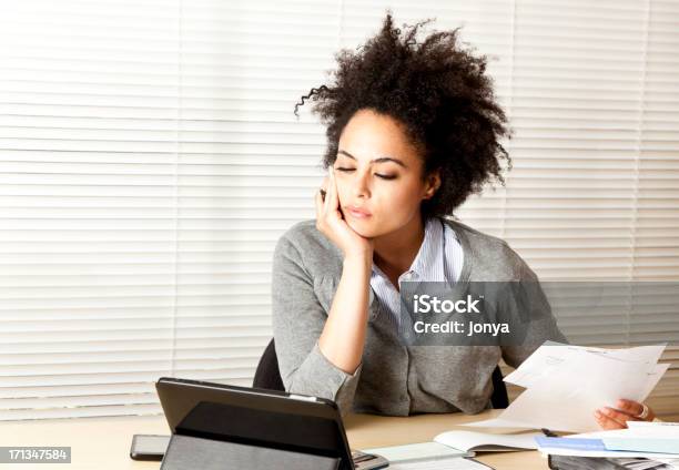 Curlyhaired Woman Doing Paperwork Stock Photo - Download Image Now - Computer, In Front Of, Bookkeeping