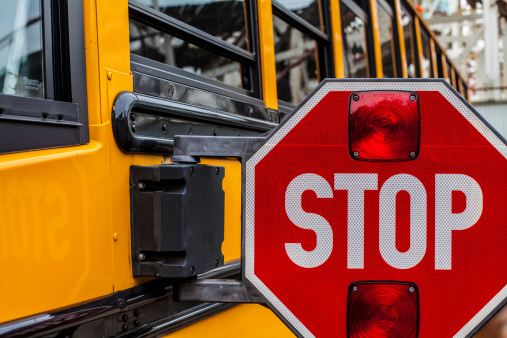 A aparking schoolbus with the stop sign for safety