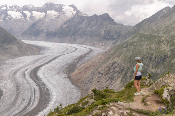 istock Female trail runner pauses on mountain pass, looking at view 1713478482