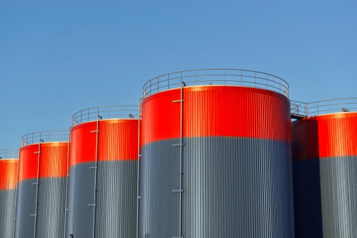 Three storage tanks with a blue sky with copy space in the background.