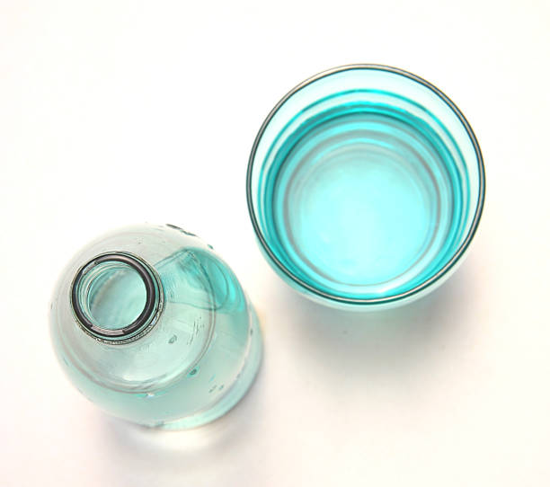 Empty bottles of milk on a wooden kitchen table. Bottle with a stopper. Black background