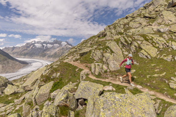 istock Female trail runner ascends alpine path in Swiss mountain landscape 1713481790