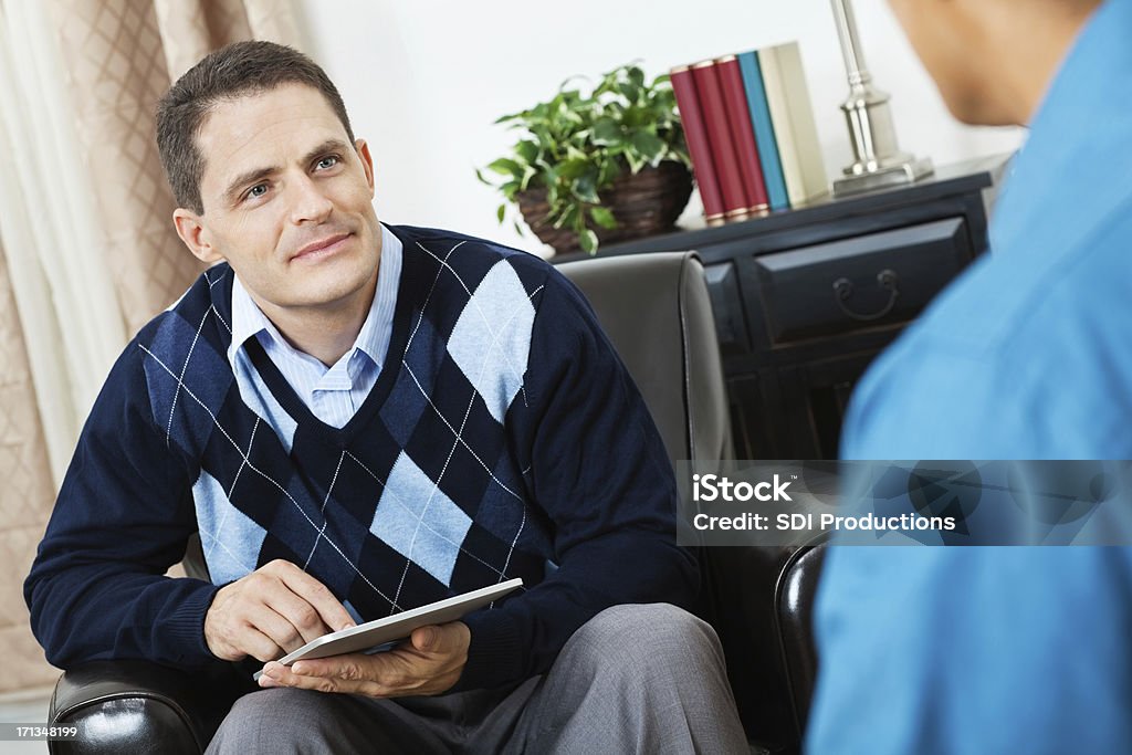 Asesor de tomar notas con tableta digital en reunión - Foto de stock de Profesional de salud mental libre de derechos