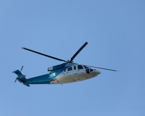 Richmond, Canada - 15th September 2023: C-CHJT, a Sikorsky S-76A helicopter operated by Helijet International with the branding of their charity Helicopters Without Borders, flying against a clear, blue sky. Vancouver South Airport, Richmond, BC,. Canada.