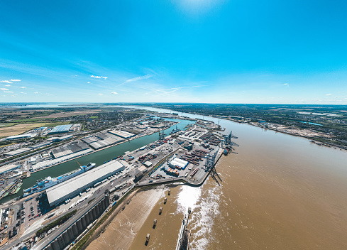 Loading grain into holds of sea cargo vessel in seaport from silos of grain storage. Bunkering of dry cargo ship with grain. Aerial top view.