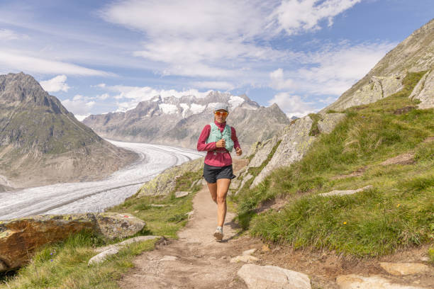 istock Female trail runner ascends alpine path in Swiss mountain landscape 1713483571
