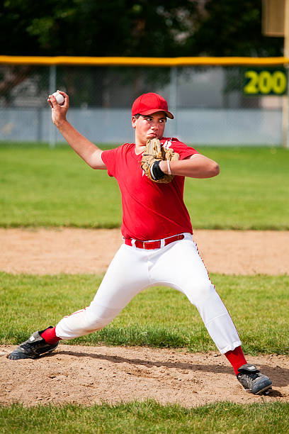 Young Male Baseball Pitcher Stretches on Pitcher's Mound A 12 year old boy pitches from mound.  (Logo design has property release from creator.) sports uniform photos stock pictures, royalty-free photos & images