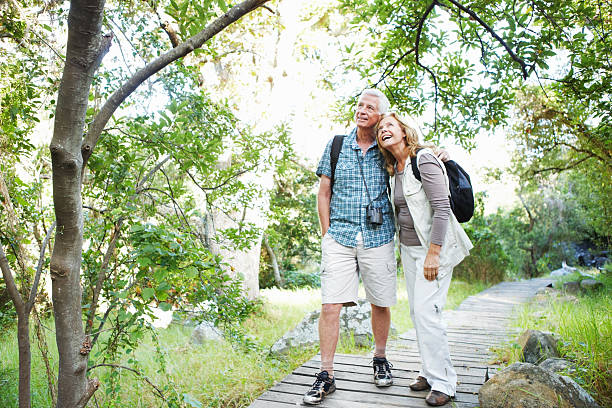 Loving senior couple standing on a pathway in the woods