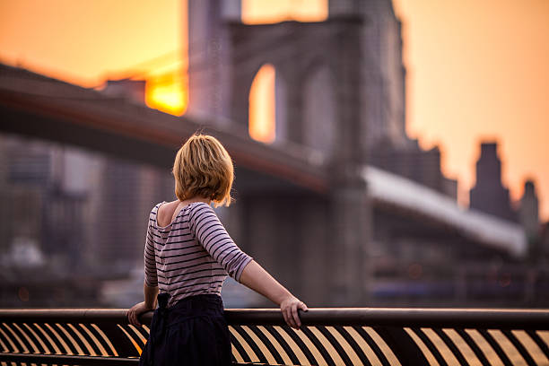 mujer joven mirando a la ciudad de nueva york - brooklyn bridge new york city brooklyn bridge fotografías e imágenes de stock