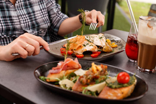 istock A man at a sumptuous dinner served on a table in a luxurious outdoor restaurant. Man's hands are cutting grilled chicken. Healthy food 1713495124