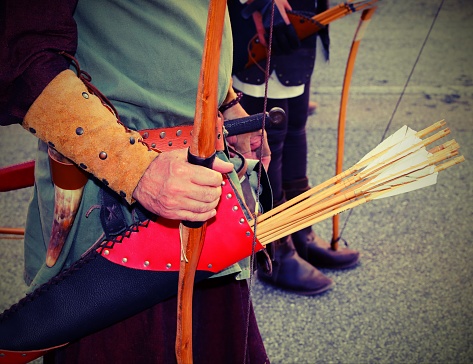 archer hunting with leather arrow holder and medieval clothes during historical reenactment and old toned effect
