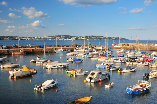 High tide in Paignton Harbour. Torquay can be seen across the bay.