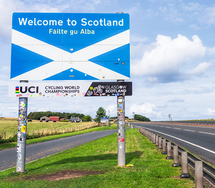 A1 Road, UK - A large Welcome to Scotland  sign featuring the Scottish saltire at the border between Scotland and England, located to the north of the English town of Berwick upon Tweed.
