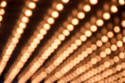 Defocused theater marquee lights in a row.