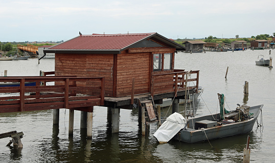 stilt houses used by fishermen and a boat on the seashore without people
