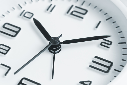 Antique clock face pointing at three o'clock isolated against white background