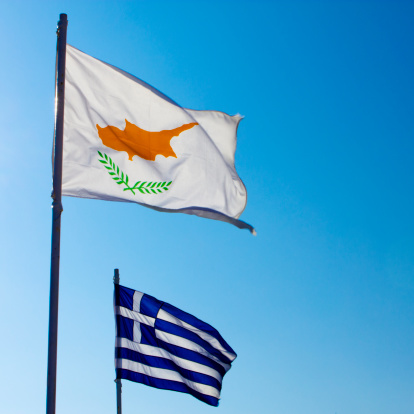 Cyprus and greek flags over clear blue sky