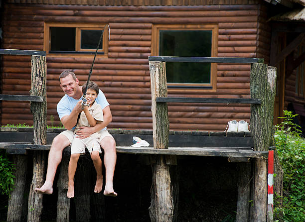 Father teaching his son how to fish in beautiful mountain lake.