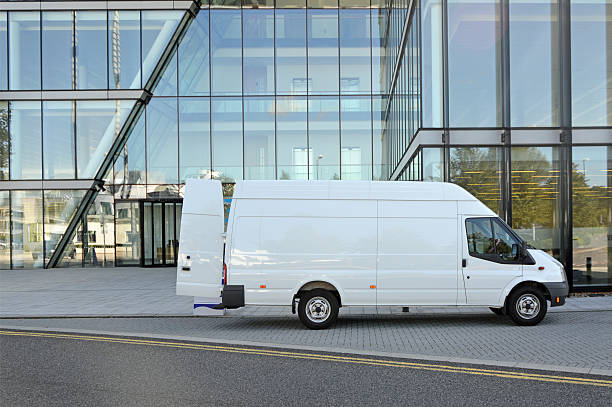 Van Delivery A white van delivering boxes to a modern office block. delivery van stock pictures, royalty-free photos & images