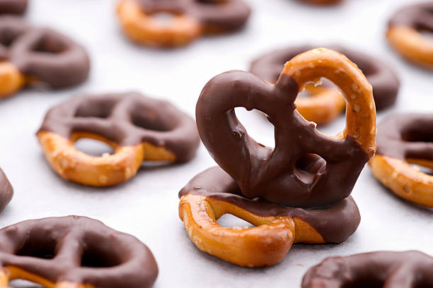 Chocolate dipped pretzels on a baking sheet Close up shot of homemade chocolate dipped pretzels. pretzel photos stock pictures, royalty-free photos & images