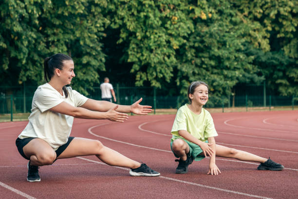istock Mother and little daughter are doing exercise in the stadium. 1713542420