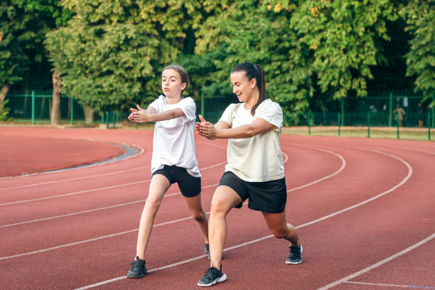 istock Mother and little daughter are doing exercise in the stadium. 1713542425