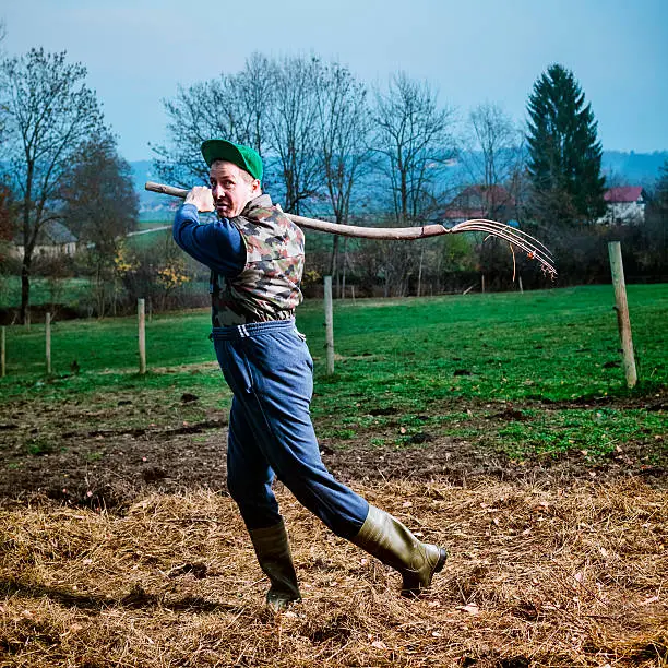 Angry farmer threatening with pitchfork.