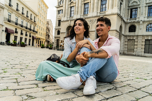 Traveler young couple sitting on town square of historic district