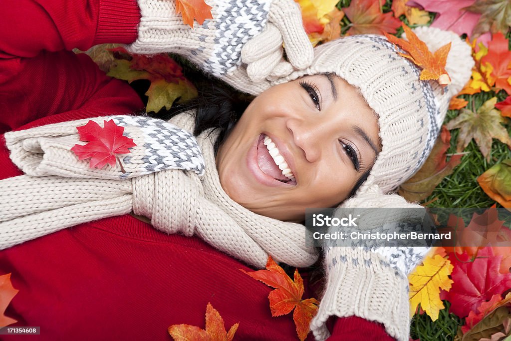 Uśmiechnięta kobieta leżący na jesień liście - Zbiór zdjęć royalty-free (20-24 lata)