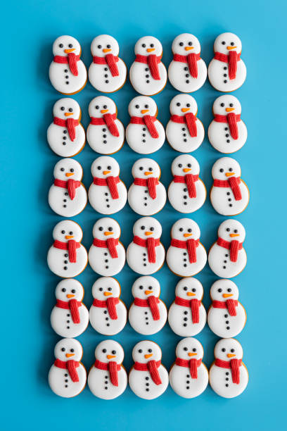 istock Gingerbread snowmen covered with icing on a blue background, flat lay. 1713546356