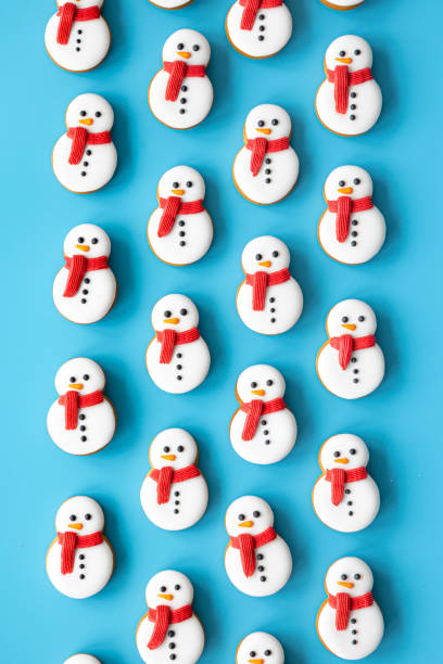 istock Gingerbread snowmen covered with icing on a blue background, flat lay. 1713546365
